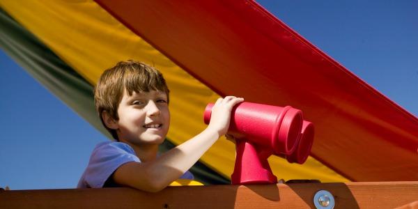 Boy Playing On Rainbow Climbing Frame With Binoculars 600x300